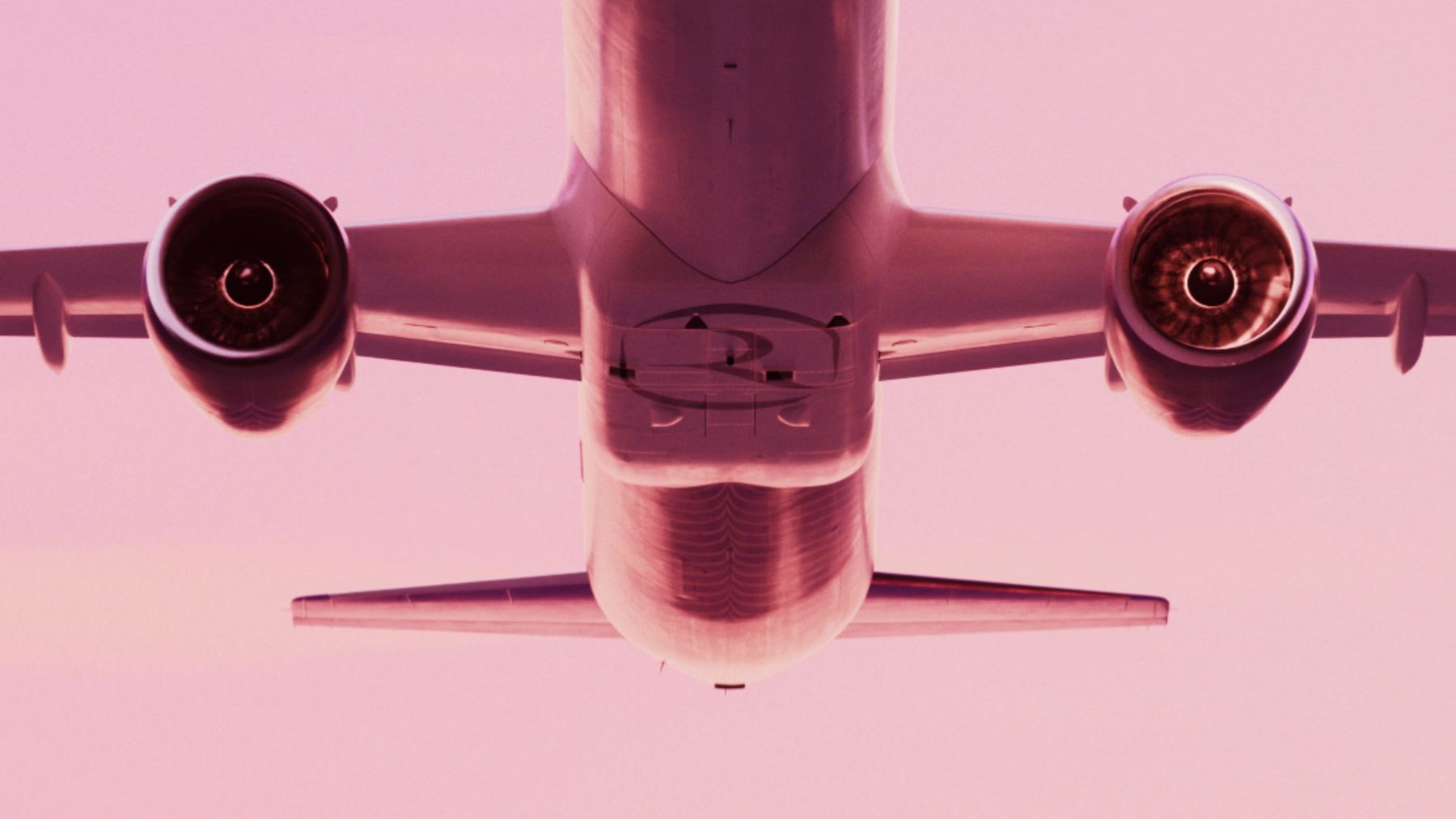 An aircraft render seen from directly below against a pink sky
