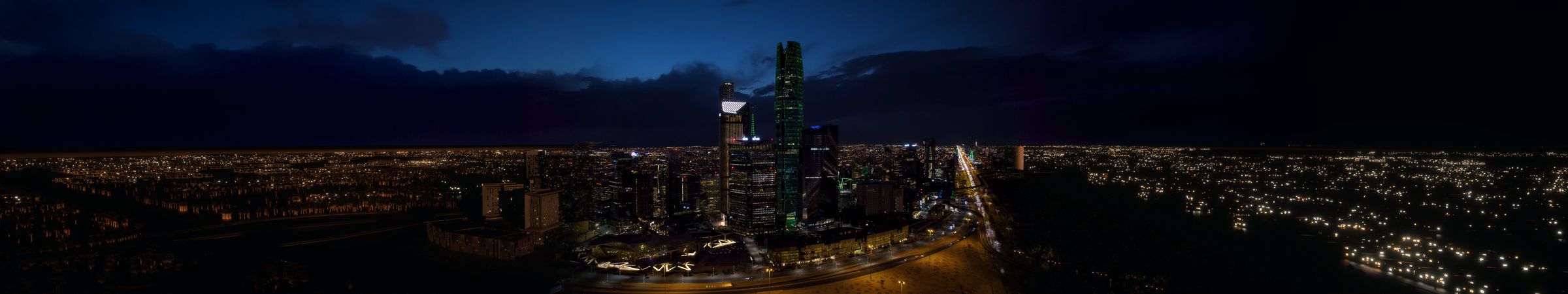 A panoramic night view of central Riyadh's towers and lit highways